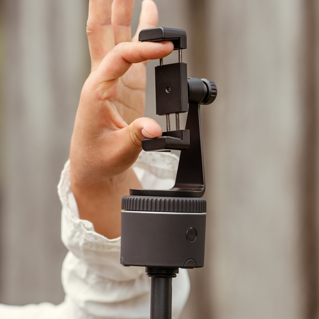 Adjustable smartphone mount with hand, showing universal design and compatibility with Pivo Pods and tripods.